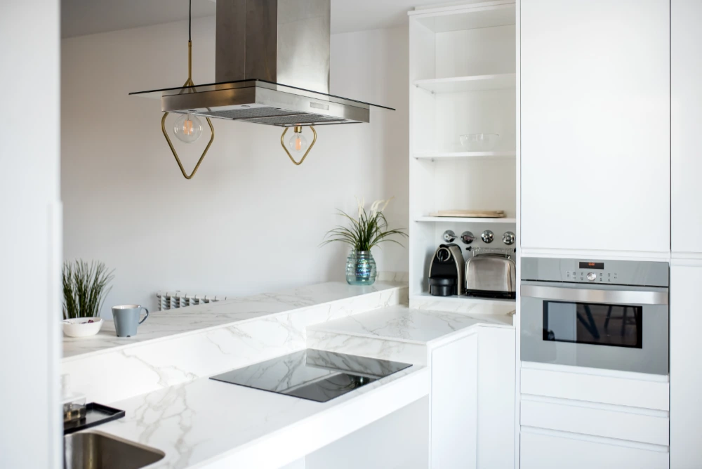 reforma integral de una cocina y salón en un único ambiente - Detalles de campana, horno, encimera y barra Reforma en Sants- Mont juïc - Renew Barcelona