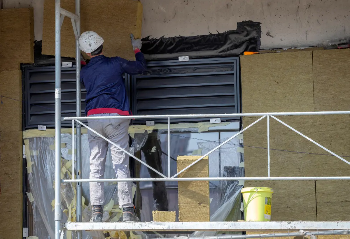 trabajador colocando placas de lana de roca en una rehabilitación de edificio en Barcelona